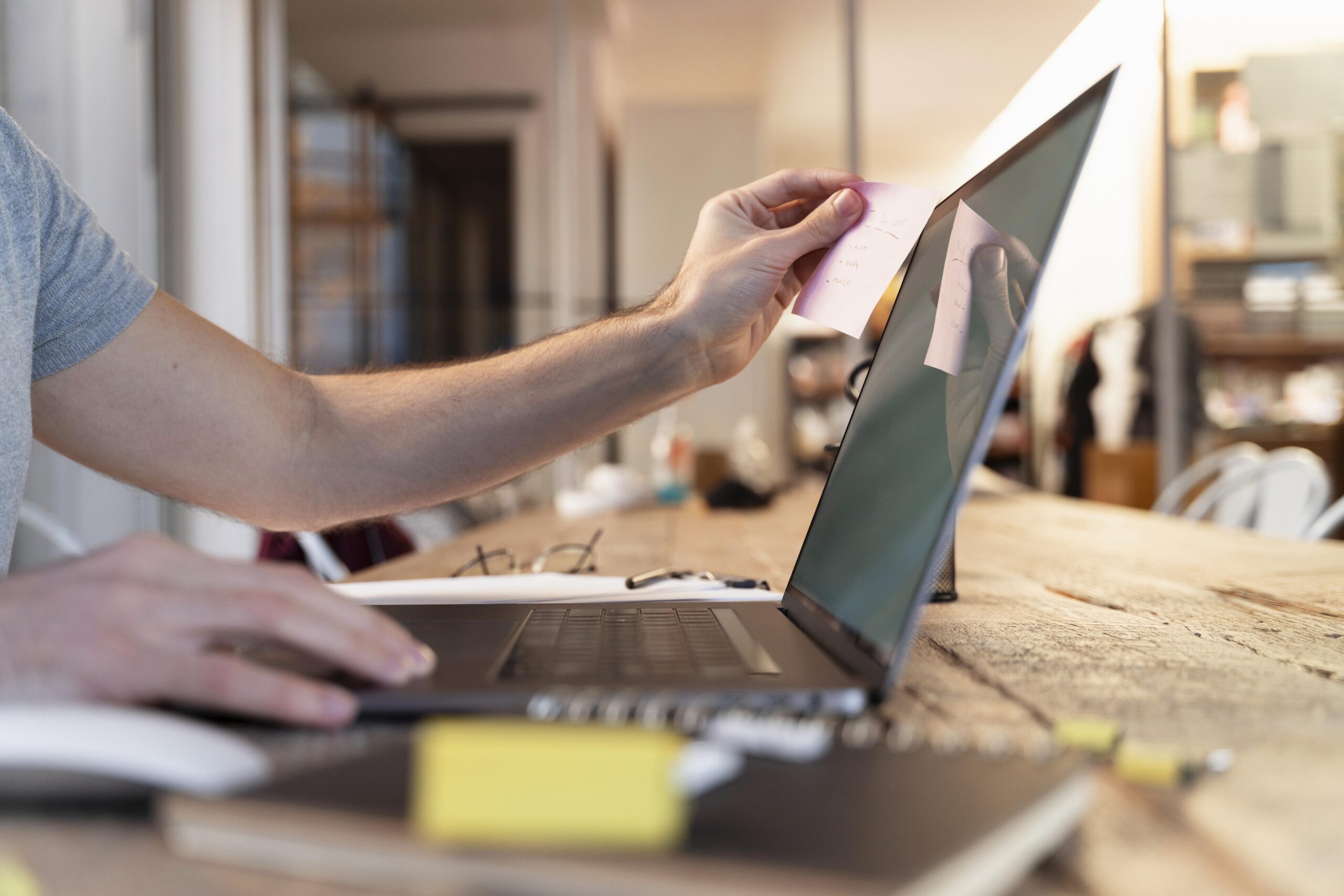 Person working on a laptop at a desk, following a beginner’s guide to using MEP project management software.